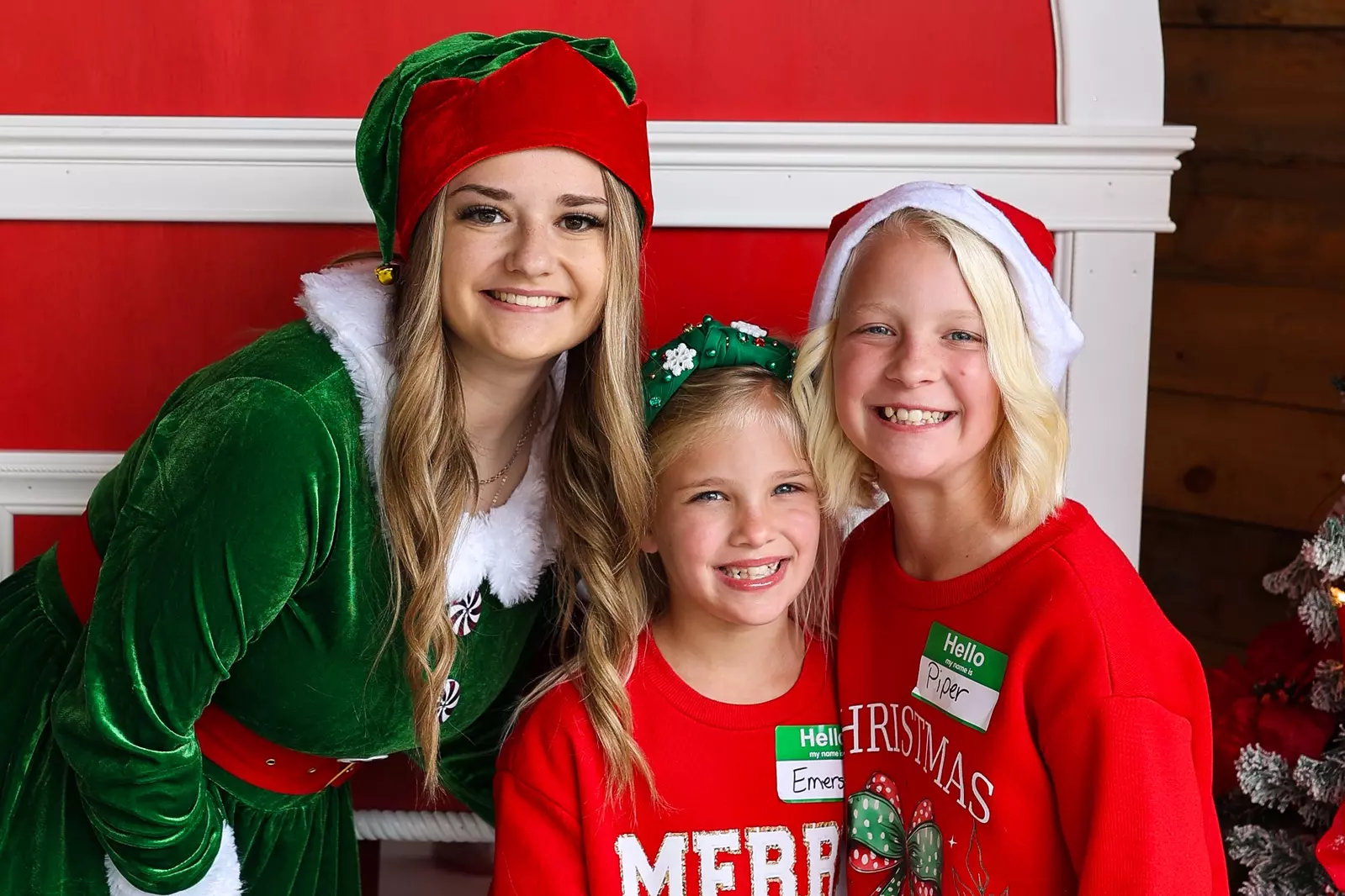 girls smiling with an employee dressed as an elf