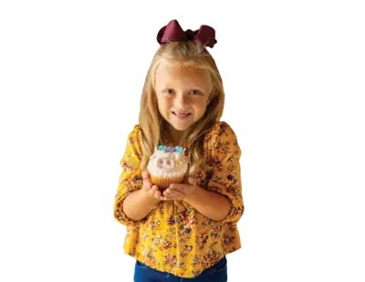 girl holding a cow shaped cupcake
